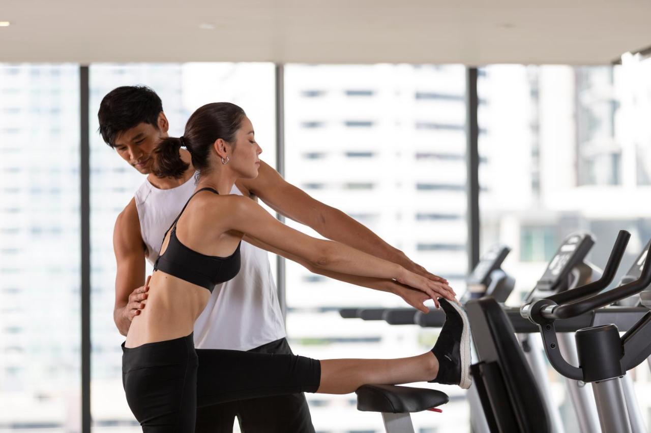 Hotel Ascott Thonglor Bangkok Zewnętrze zdjęcie A personal trainer assisting a woman with a stretching exercise